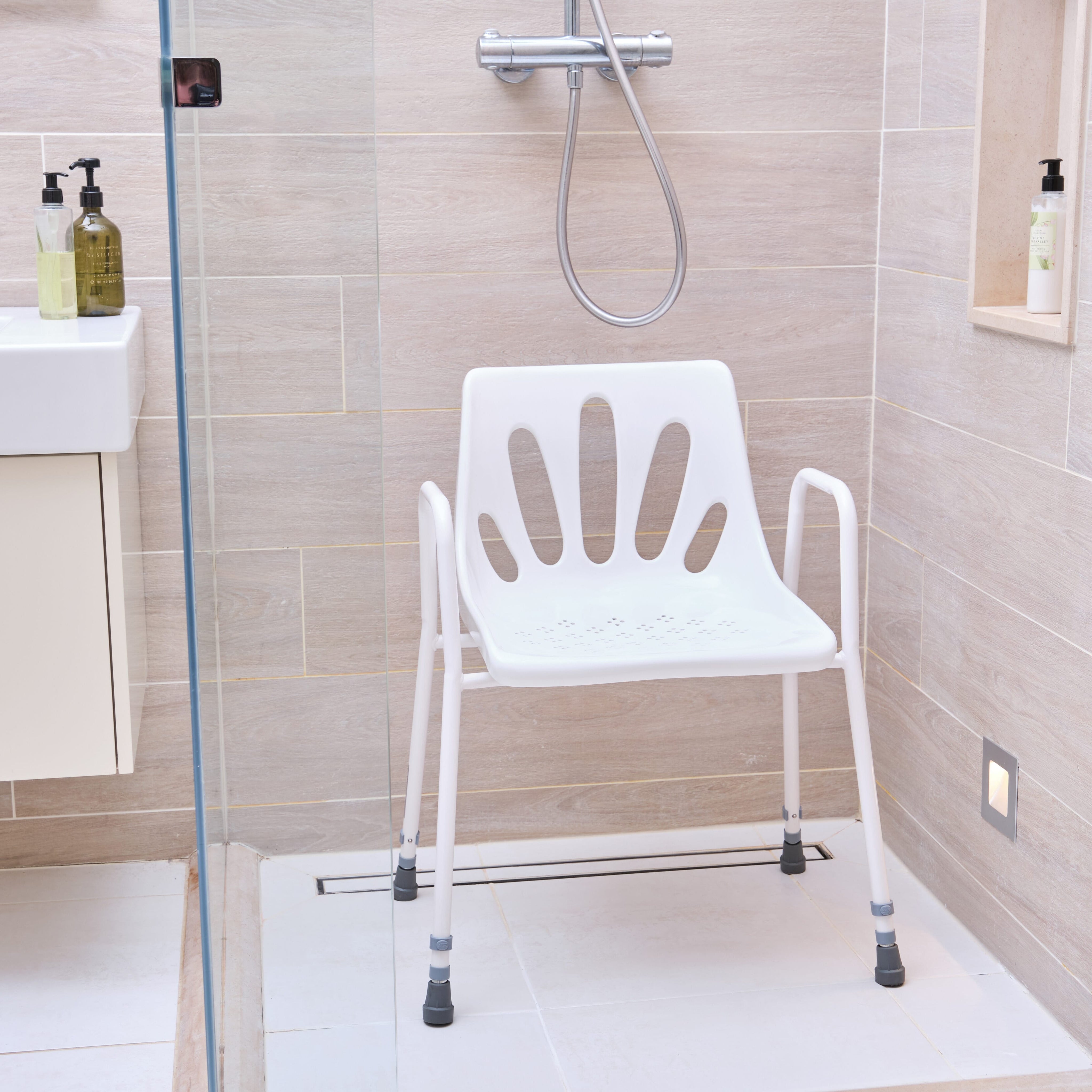 Close-up of the seat on NRS Stackable Adjustable Shower Chair, showing drainage holes and textured surface for comfort.