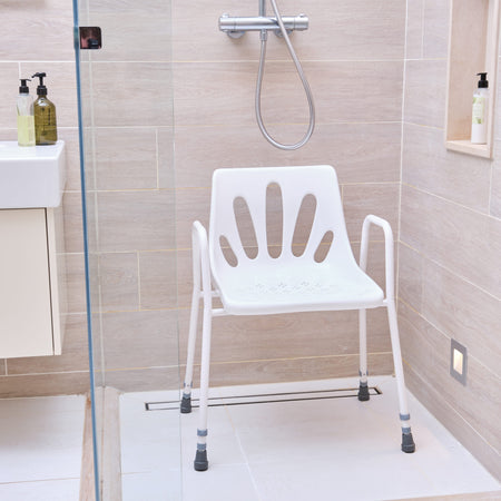 Close-up of the seat on NRS Stackable Adjustable Shower Chair, showing drainage holes and textured surface for comfort.