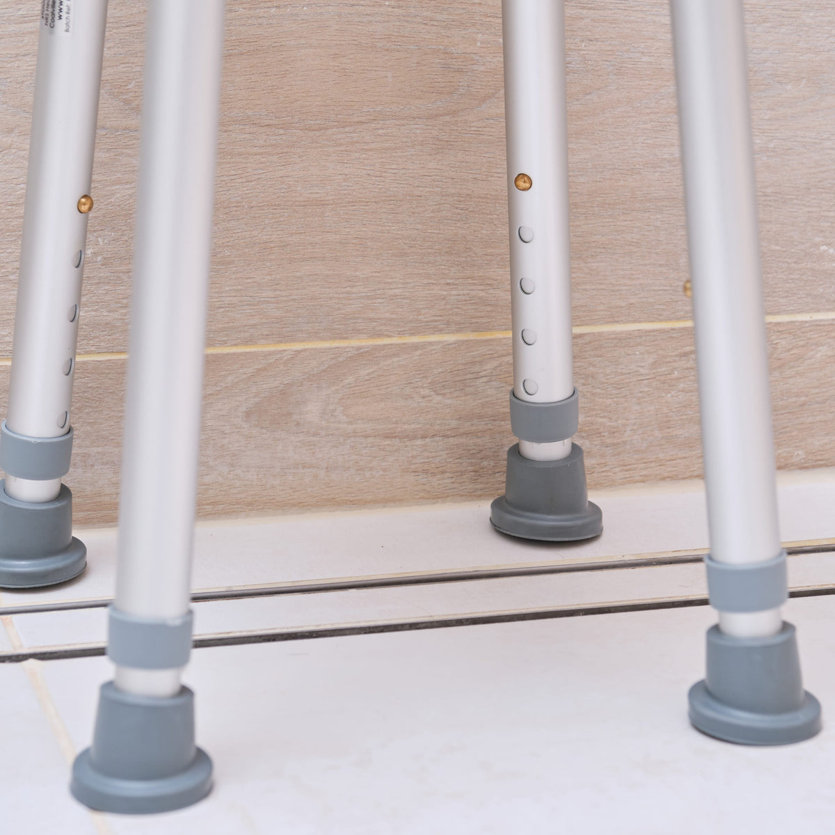 Close-up of a leg on NRS Swivel Shower Stool shower stool, showing the height adjustment holes and rubber ferrule.