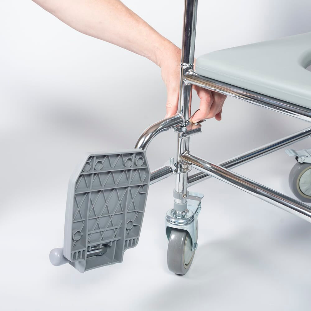 NRS Wheeled Commode Footrests positioned in a home environment such as a bedroom or bathroom, demonstrating its discreet appearance.