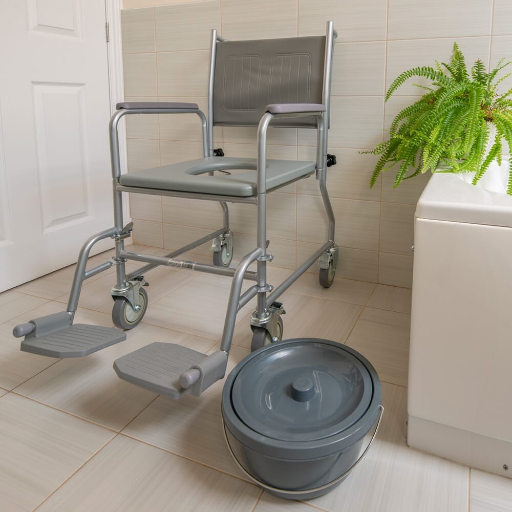 NRS Wheeled Commode positioned in a home environment such as a bedroom or bathroom, demonstrating its discreet appearance.