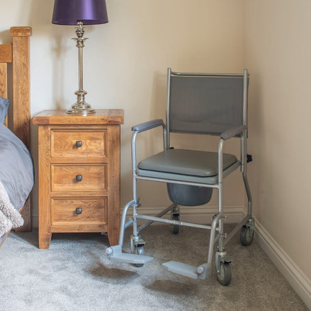 Demonstration of removing the commode pan or adjusting the height on NRS Wheeled Commode.