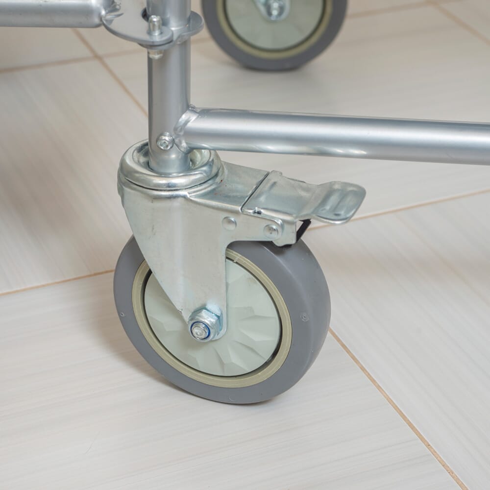 Person emptying or cleaning the commode pan of NRS Wheeled Commode into a standard toilet.