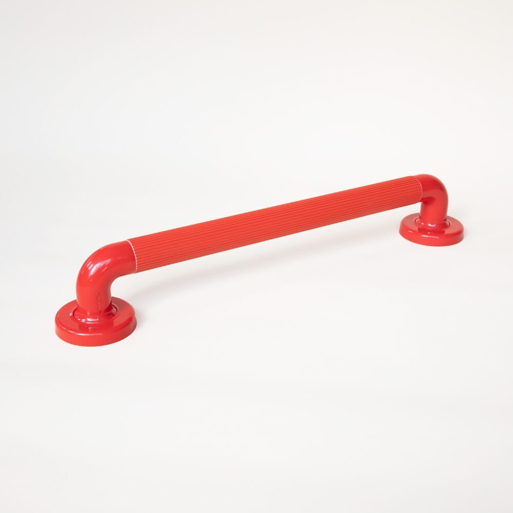 Plastic Fluted Grab Rail-450mm 18-Red installed next to a bath, shower or toilet, illustrating how it offers extra support and stability.