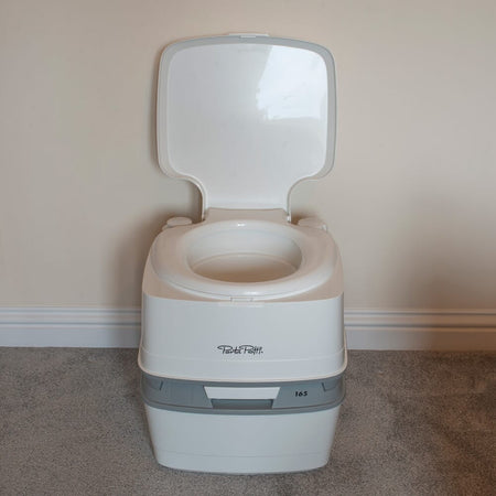 Diagram or packaging of Porta Potti 165 Portable Flushing Toilet highlighting dimensions or features.