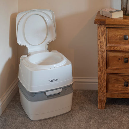 Diagram or packaging of Porta Potti 165 Portable Flushing Toilet highlighting dimensions or features.