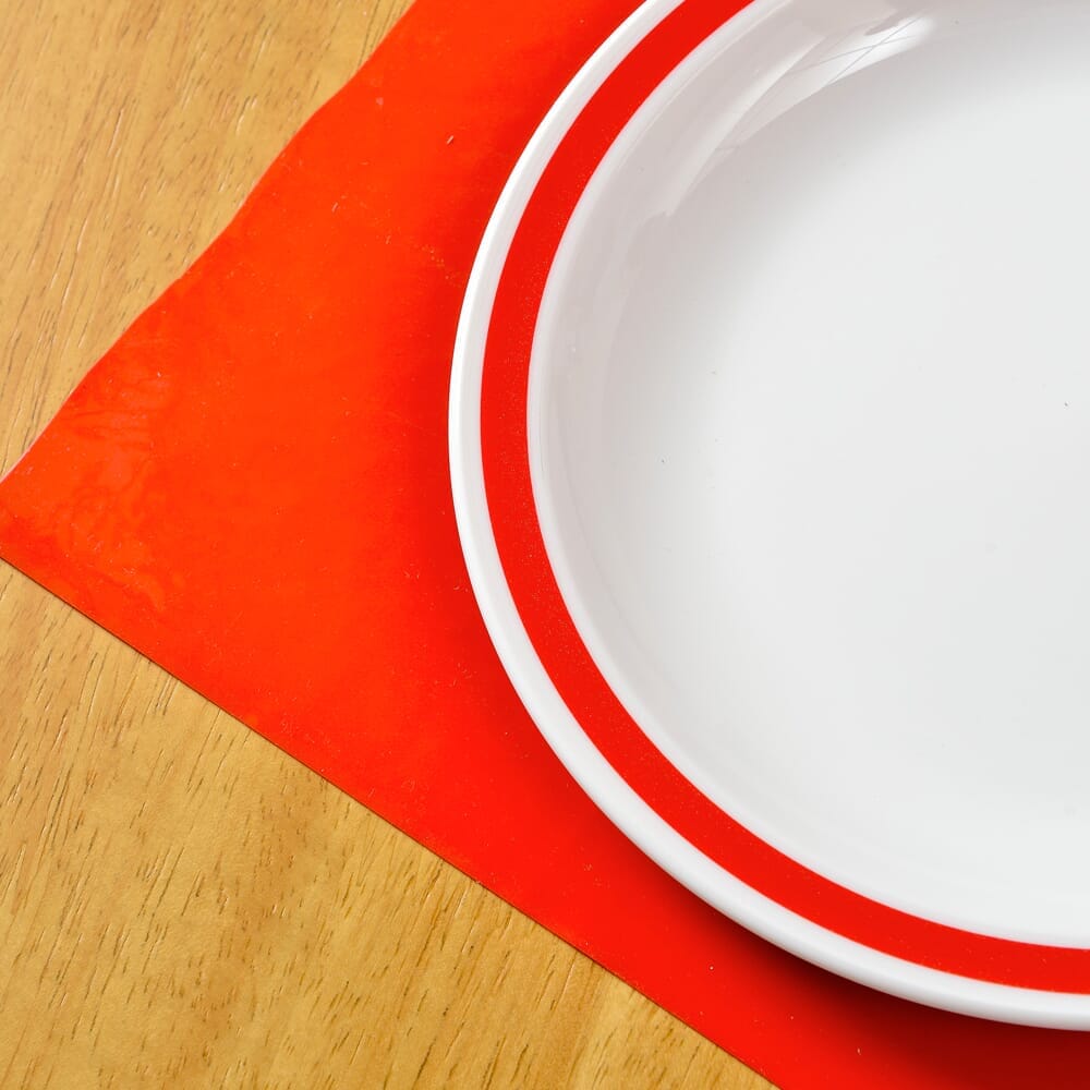 Lifestyle image of Red Rimmed Plate being used in a real-life setting.