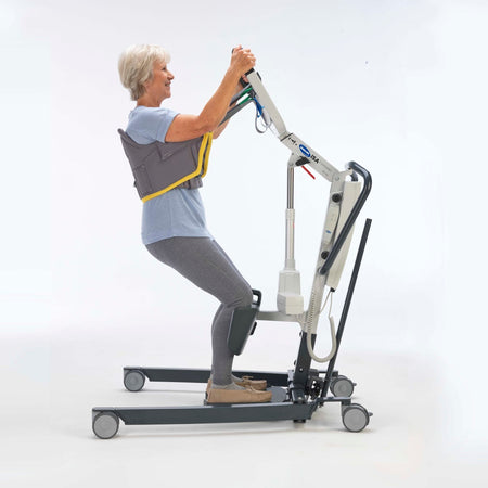 Full view of Stand Aid Sling mobile hoist on a plain background, showing the wheeled base, upright mast and sling attachment.